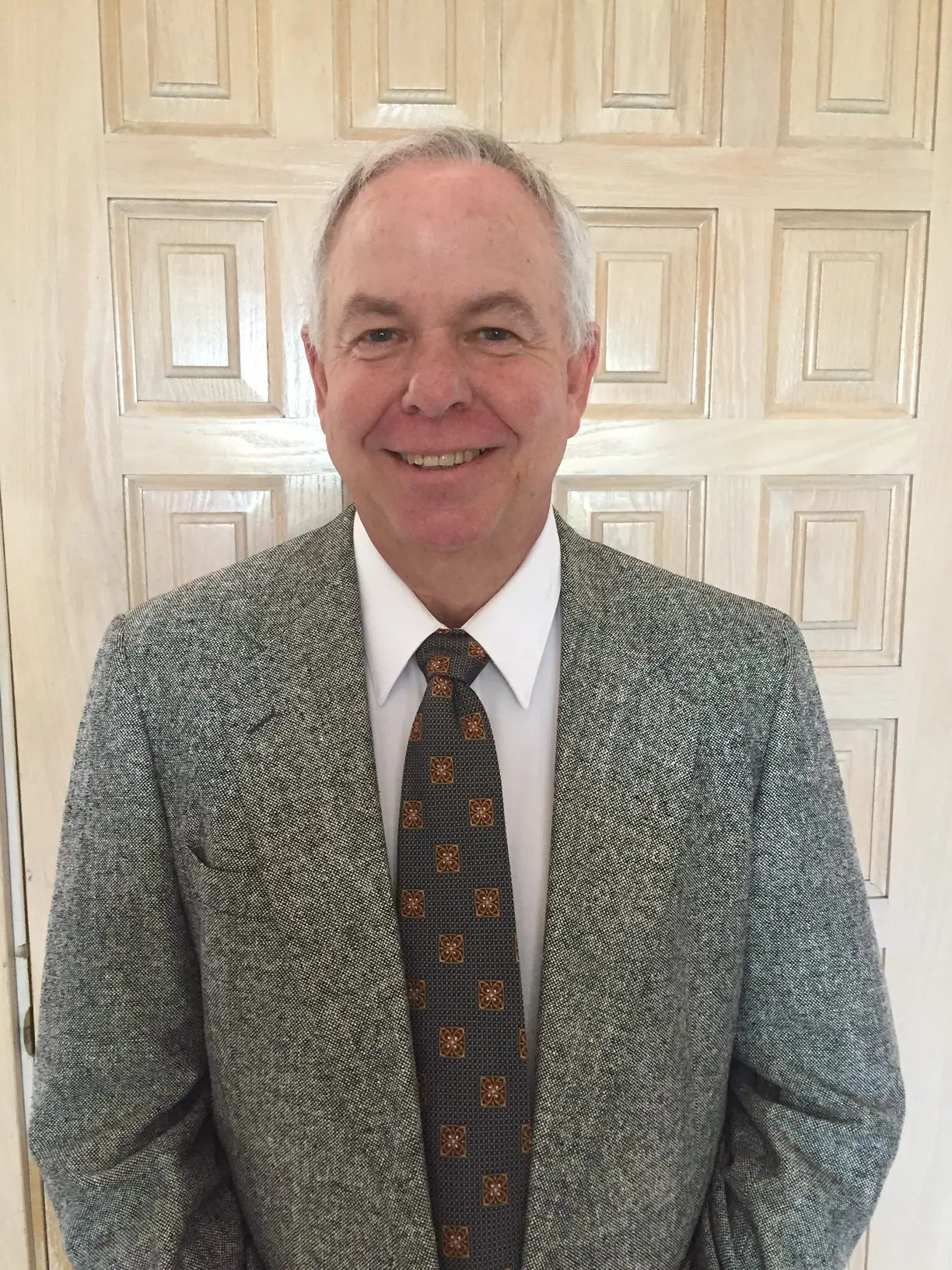 Smiling man in a gray suit and tie