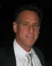 Man in suit and tie smiling.